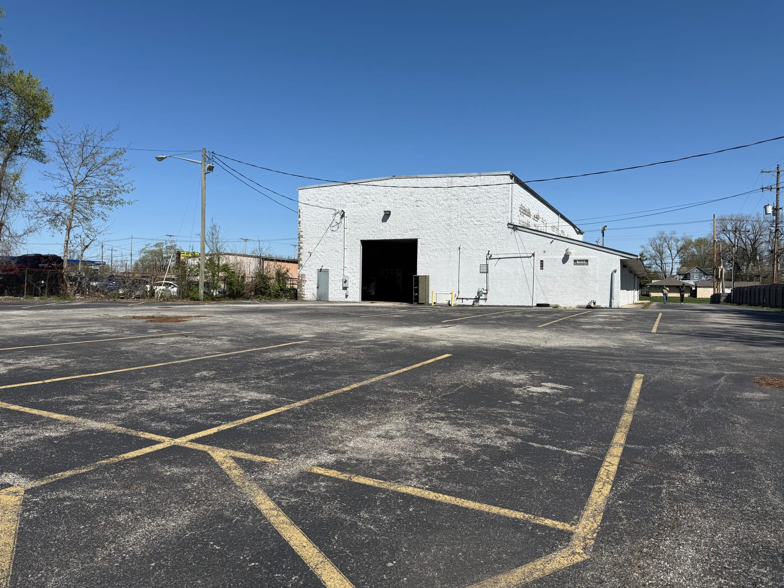 White industrial building with a large drive-in door and an open paved lot at 3875-3883 E Livingston in Columbus, OH